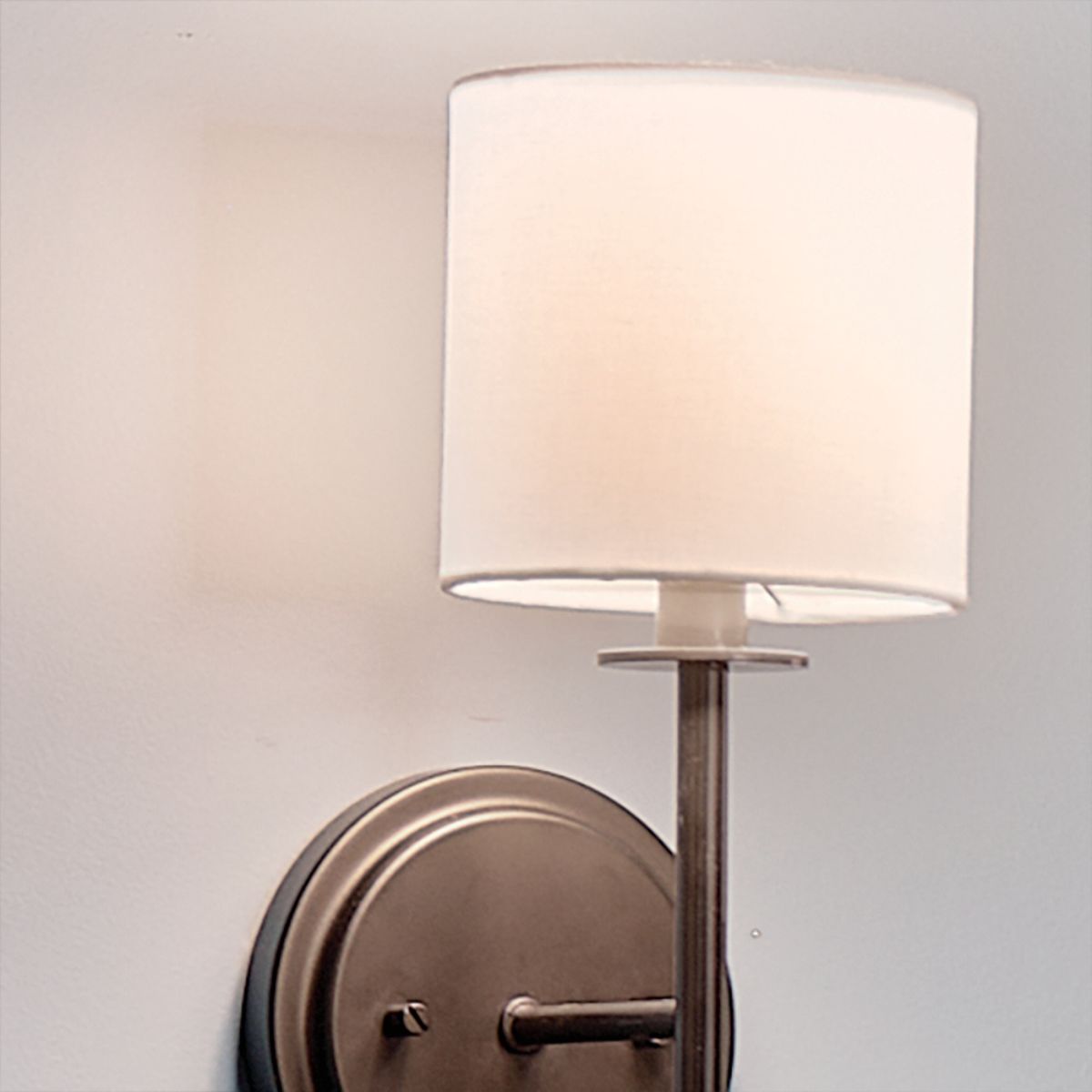 a light wall sconce with a round shade